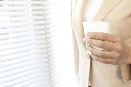 Office lady having a paper cupの写真素材