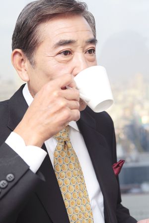 Japanese executive drinking coffeeの写真素材