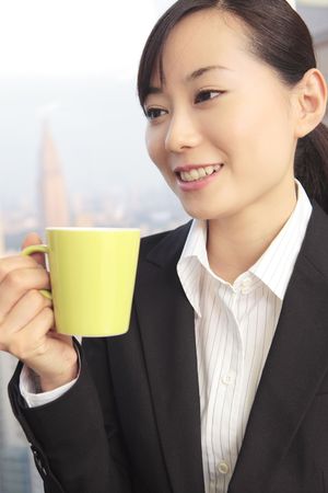 Japanese office lady drinking coffeeの写真素材