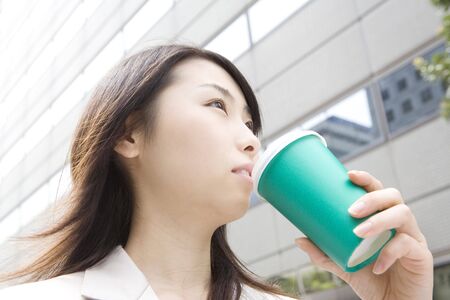 Business lady walking and drinking a coffeeの写真素材