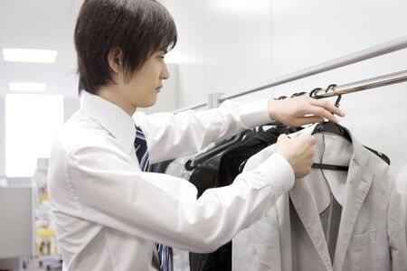 Office worker hanging a jacket on a hangerの写真素材