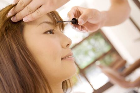 Japanese girl puts on makeupの写真素材