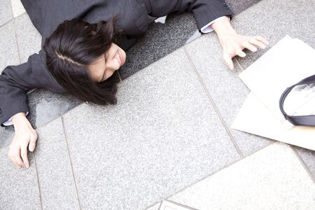 Japanese office worker falling down on the streetの写真素材