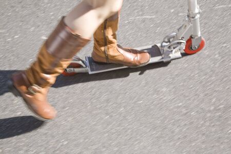 Foot of woman riding a kick scooterの写真素材