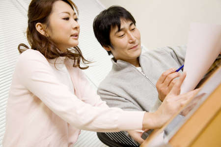Japanese office workers having brief meetingの写真素材