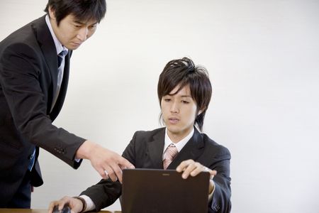 Japanese office workers having breif meetingの写真素材