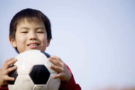 Japanese boy holding a soccer ballの写真素材