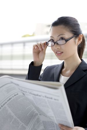 Business lady who reads a newspaperの写真素材