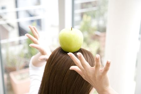 Green apple on the top of woman's headの写真素材