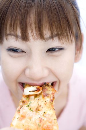 Japanese woman eating a pizzaの写真素材
