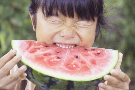 Japanese girl eating a water melonの写真素材
