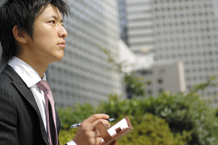 Businessman writing a schedule to the notebookの写真素材