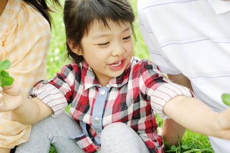 Girl to pass a wild grass that picked to parentsの写真素材