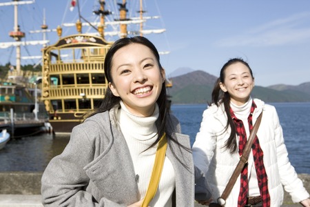 2 women walking the lakeの写真素材