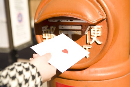 Hand of the woman who posted a letter to postの写真素材