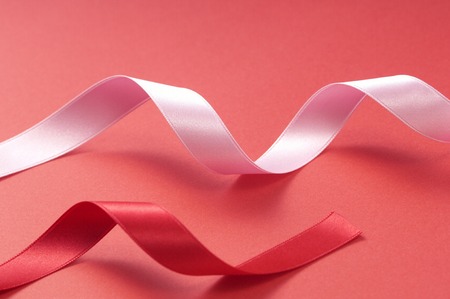A rolling two colored ribbon on red floor.の写真素材