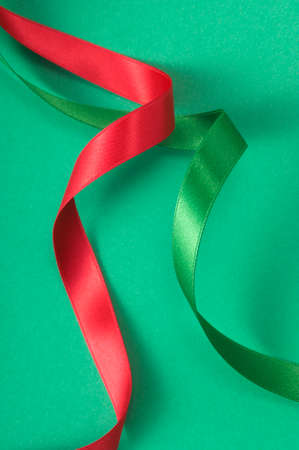 Rolling two kinds of colored ribbon on green floor.の写真素材