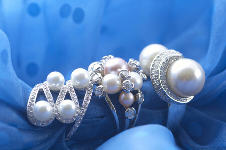 The accessory made by silver and peals on the blue fabric.の写真素材