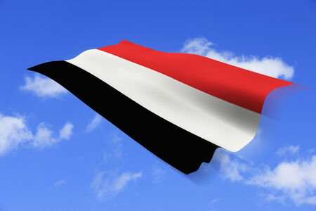 Yemen national flag and blue sky background.の写真素材