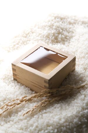 A wooden square cup of sake on riceの写真素材