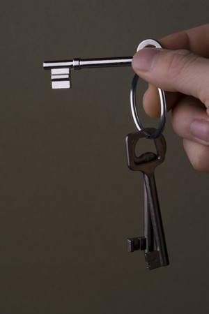 Hand holding key on brown backgroundの写真素材