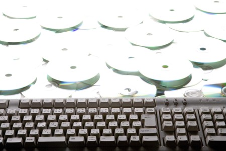 keyboard on pile of many CDs or DVDsの写真素材