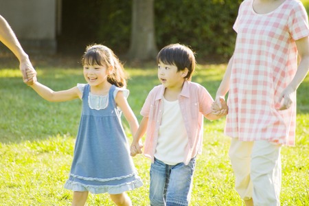 Family for a walk in the park hand in handの写真素材