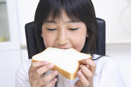 Girl eat breadの写真素材