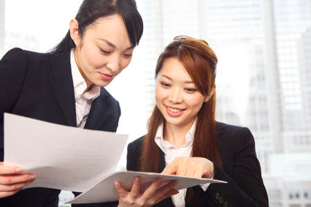 Office Lady for a meeting while looking at the documentの写真素材