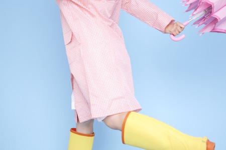 Female image to jump wearing rain gearの写真素材