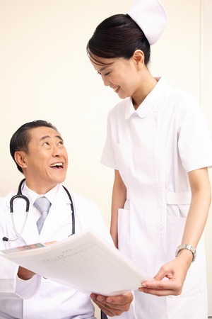 Nurse to pass a medical record to the doctorの写真素材