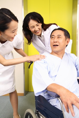 Female doctor and nurses to talk with the patient in the hallwayの写真素材