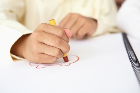 Hand of a child to draw a picture with a crayonの写真素材