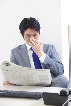 Businessman reading newspaperの写真素材