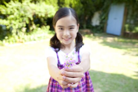 Girl smiling with a flowerの写真素材