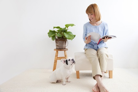 Woman to a French bulldog and readingの写真素材