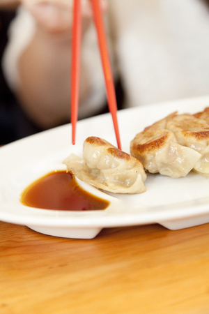 Hand of a woman eating dumplingsの写真素材