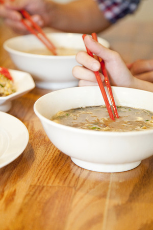 Hand of men and women to eat ramenの写真素材