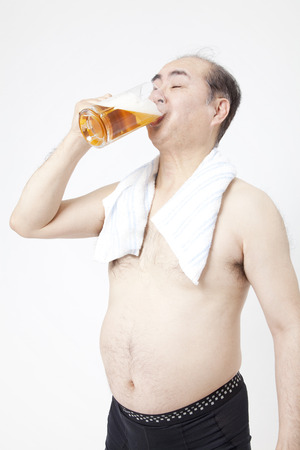 Metabo men drinking beer in the bathの写真素材