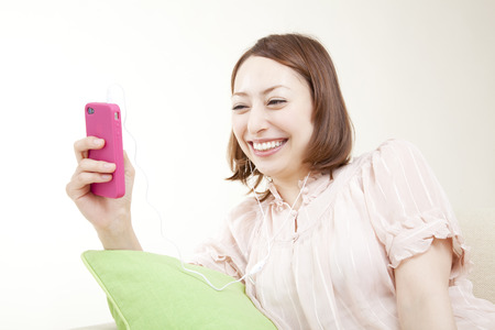 Women in smart phones to listen to musicの写真素材