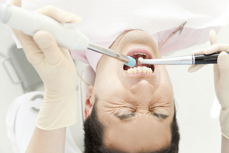 Men receiving dental treatmentの写真素材