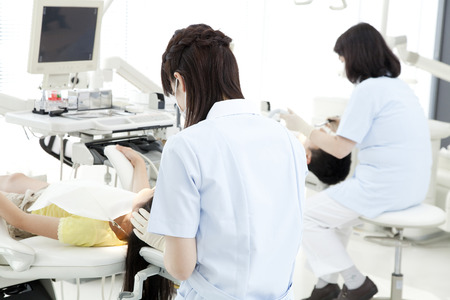 From behind of dental hygienists to treatの写真素材