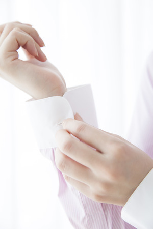 Woman to stop the button of the sleeveの写真素材