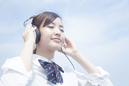 High school girls listening to music with headphonesの写真素材
