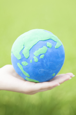 Hand to put the globe of clayの写真素材