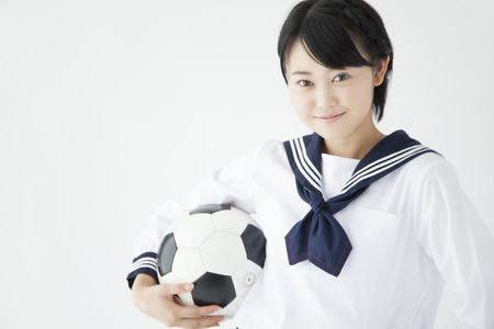 Female junior high school student with a soccer ballの写真素材