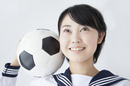 Female junior high school student with a soccer ballの写真素材