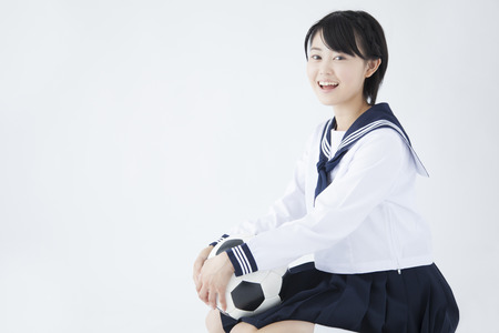 Female junior high school student with a soccer ballの写真素材