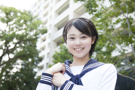 Middle school girls to smile in front of the apartmentの写真素材