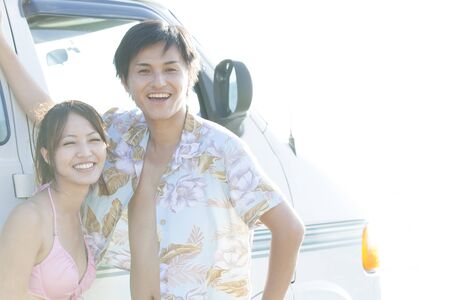 Men and women smiling in front of the camper